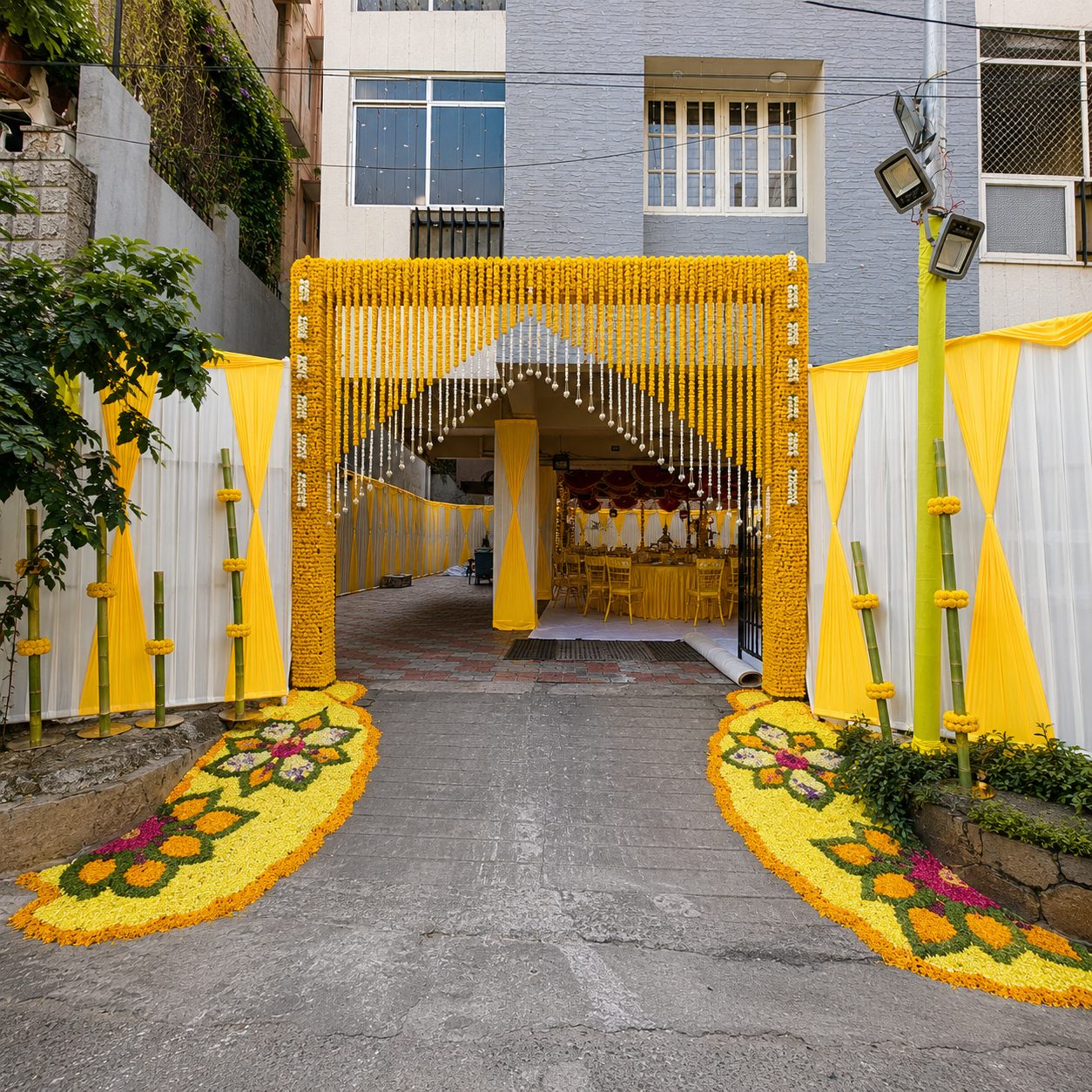 Housewarming entrance after decoration with marigold arch, yellow drapes and floral rangoli